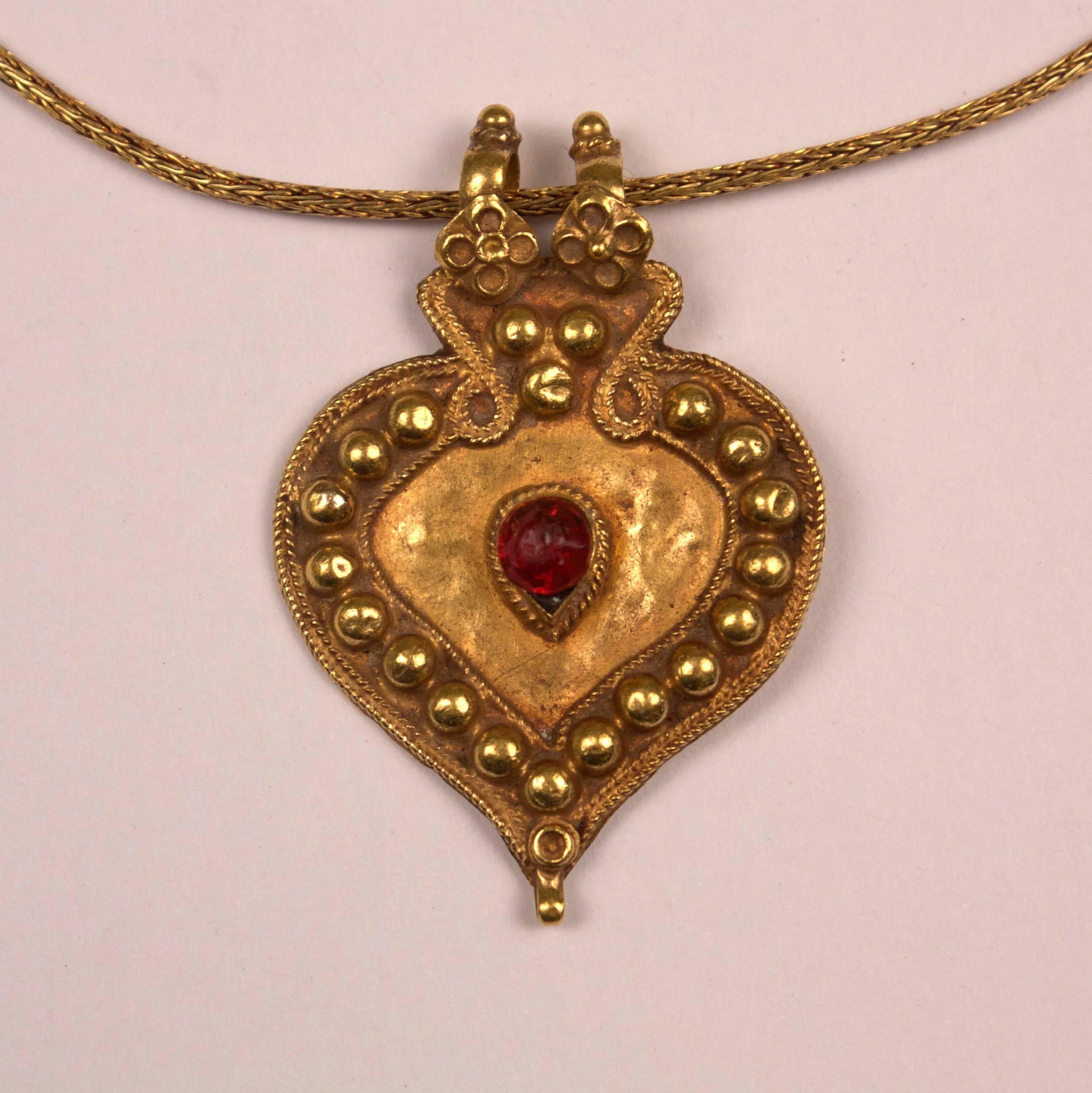 Traditional 22-karat gold pendant with rich tone, raised gold bead work and a ruby red glass centerpiece. This 1920s Rajasthani pendant hangs from a contemporary 18-karat gold chain with unscrewable end. See image number 4. Pendant measures: