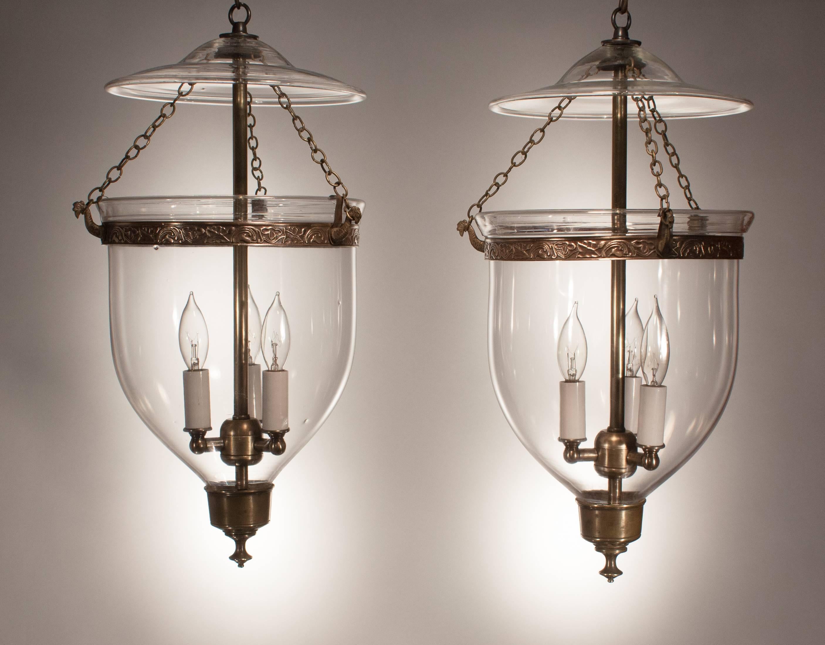 These especially lovely English bell jar lanterns, circa 1860, emanate light and character through their crystal clear handblown glass. The embossed brass bands (which have been replaced for stability) add just the right amount of ornamentation, and