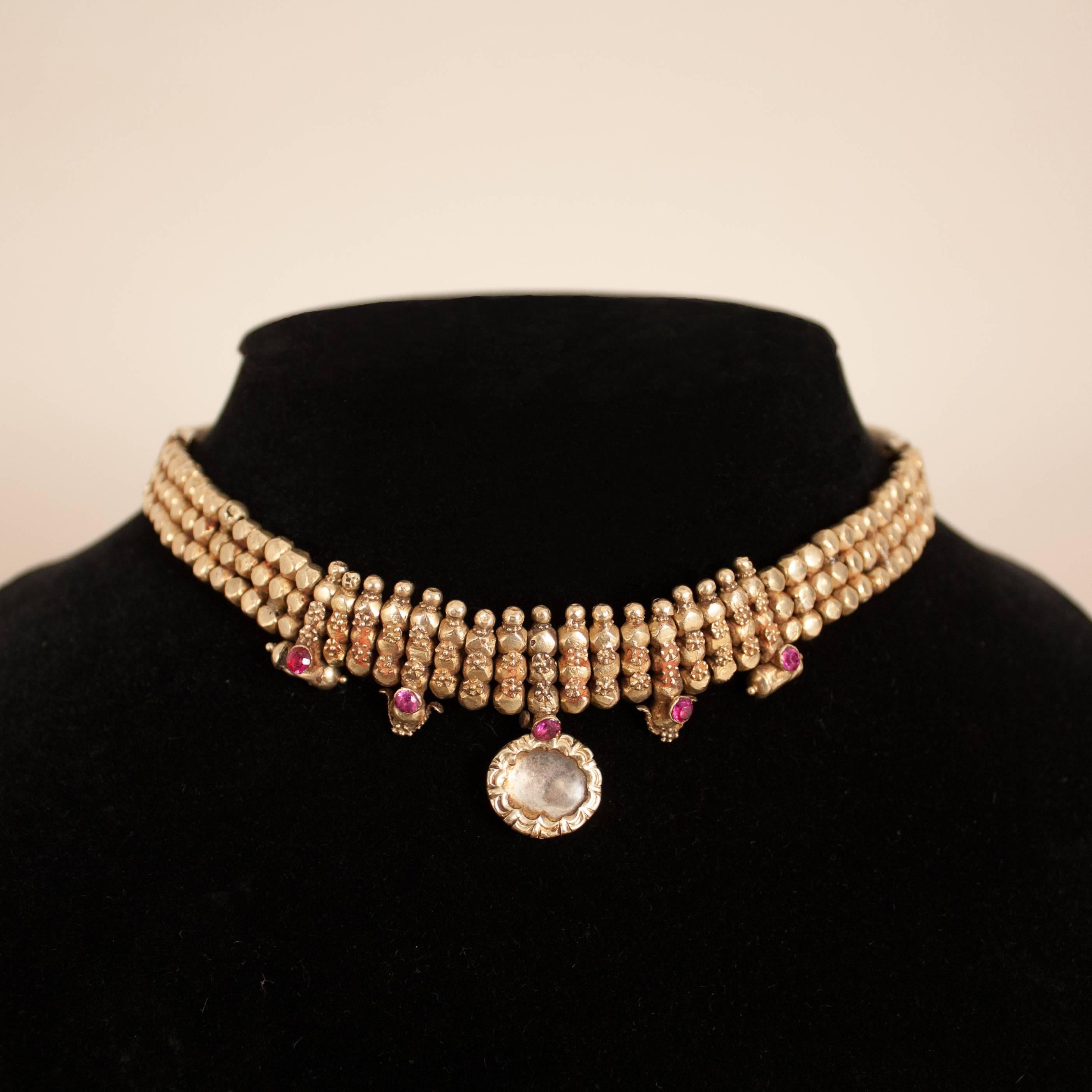 Traditional 22-karat gold over wax bead choker, circa 1930, from Rajasthan, India. This exquisite necklace is adorned with fine gold granulation work, five faceted rubies, a foil backed crystal centrepiece, two delicate amulets, and two ornaments.