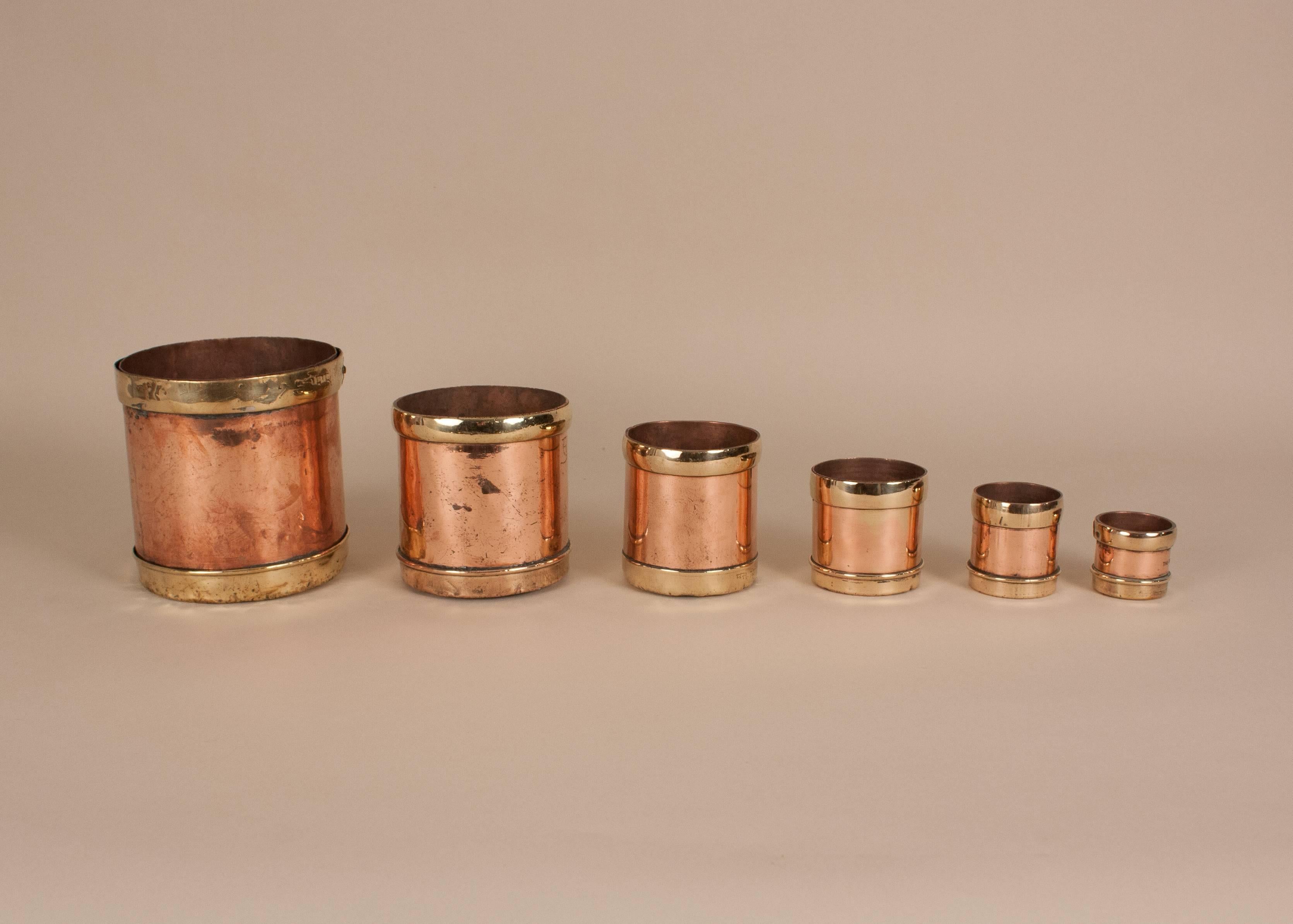 Set of six nesting copper and brass seer measures, circa 1920, ranging in size from 1/16 seer to 2 seer. Manufactured in Bombay, the cups have wonderful patina and multiple metal work markings. The set can be displayed with or without markings, as