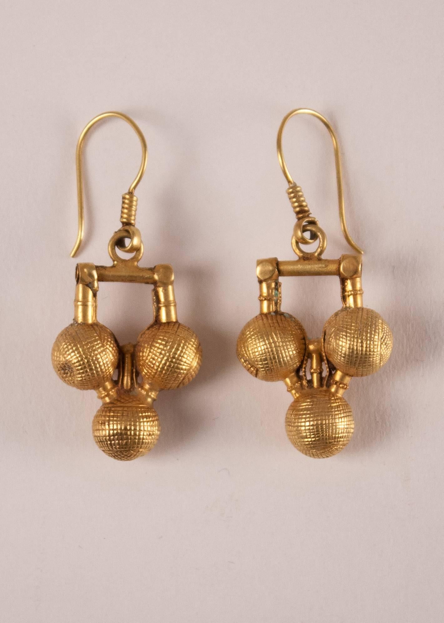 Rare pair of traditional, hand tooled 22-carat gold over wax core "three ball" dangle earrings from Rajasthan, India, circa 1940. At 3.2 grams each, the set is lightweight and easy to wear. Some subtle surface wear attests to the age and