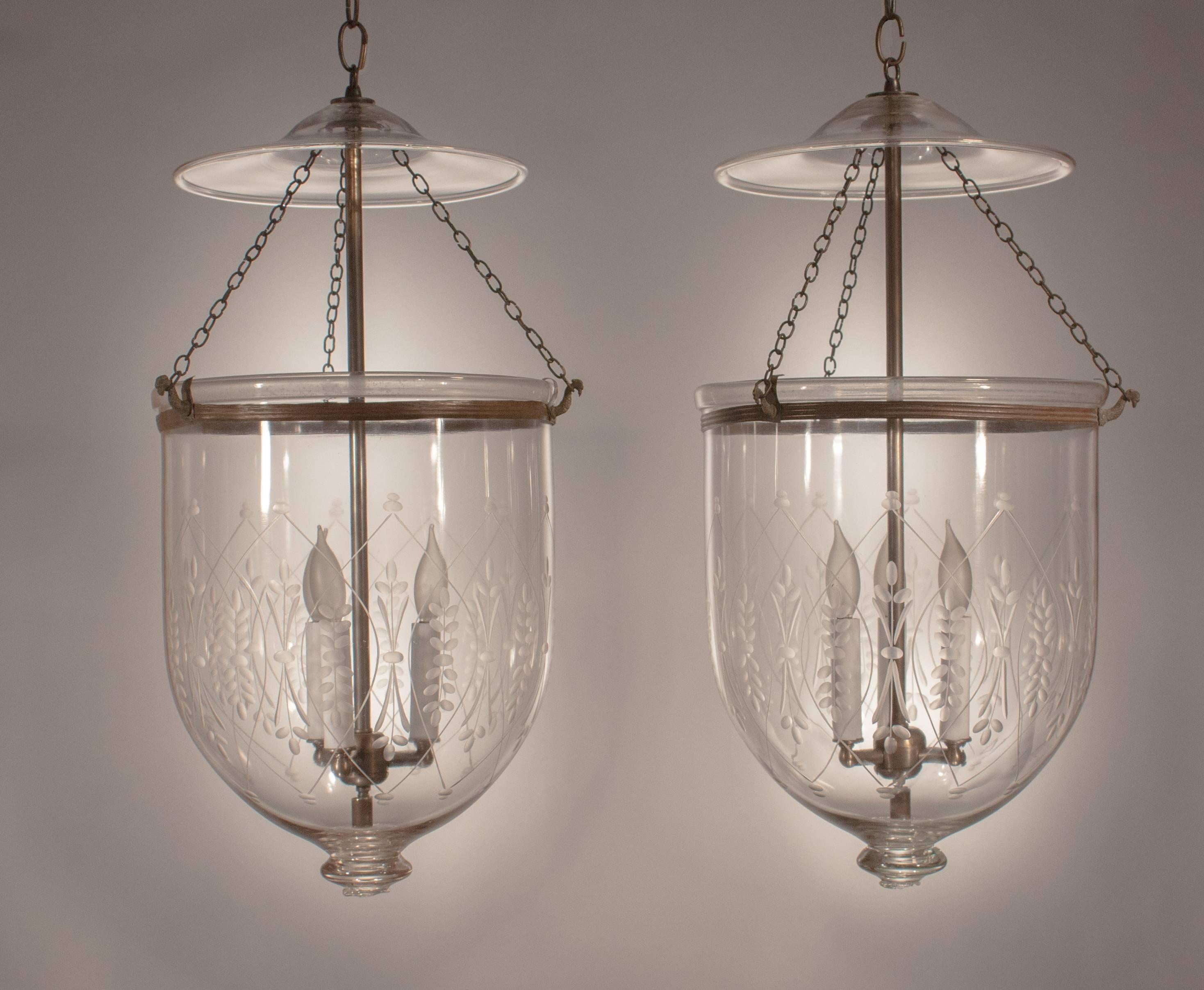 A well-matched pair of large glass bell jar lanterns, circa 1890, with an etched wheat stalk design. Voluminous in form, these authentic 19th century hall lanterns have their original smoke bells and ribbed brass bands. Hand blown by S and C Bishop