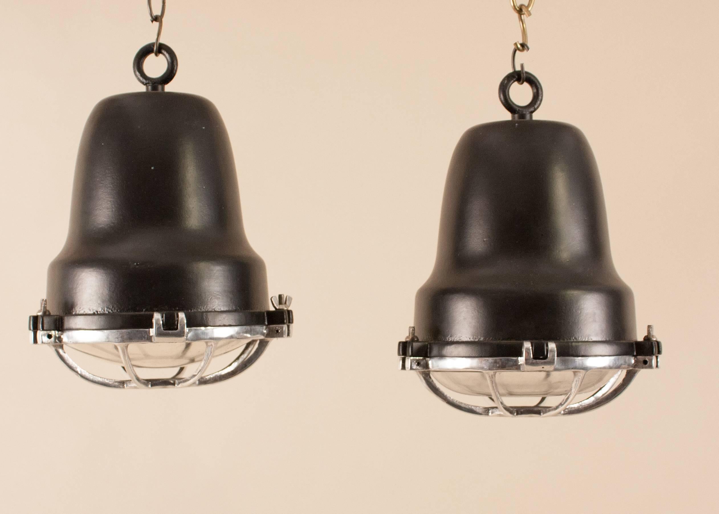 Very good-looking pair of aluminum and black powder-coated marine or industrial pendants, circa 1970. Manufactured for use on merchant vessels by Circle D of Carlstadt, NJ, the spotlights have weatherproof convex lenses protected by cast aluminum,