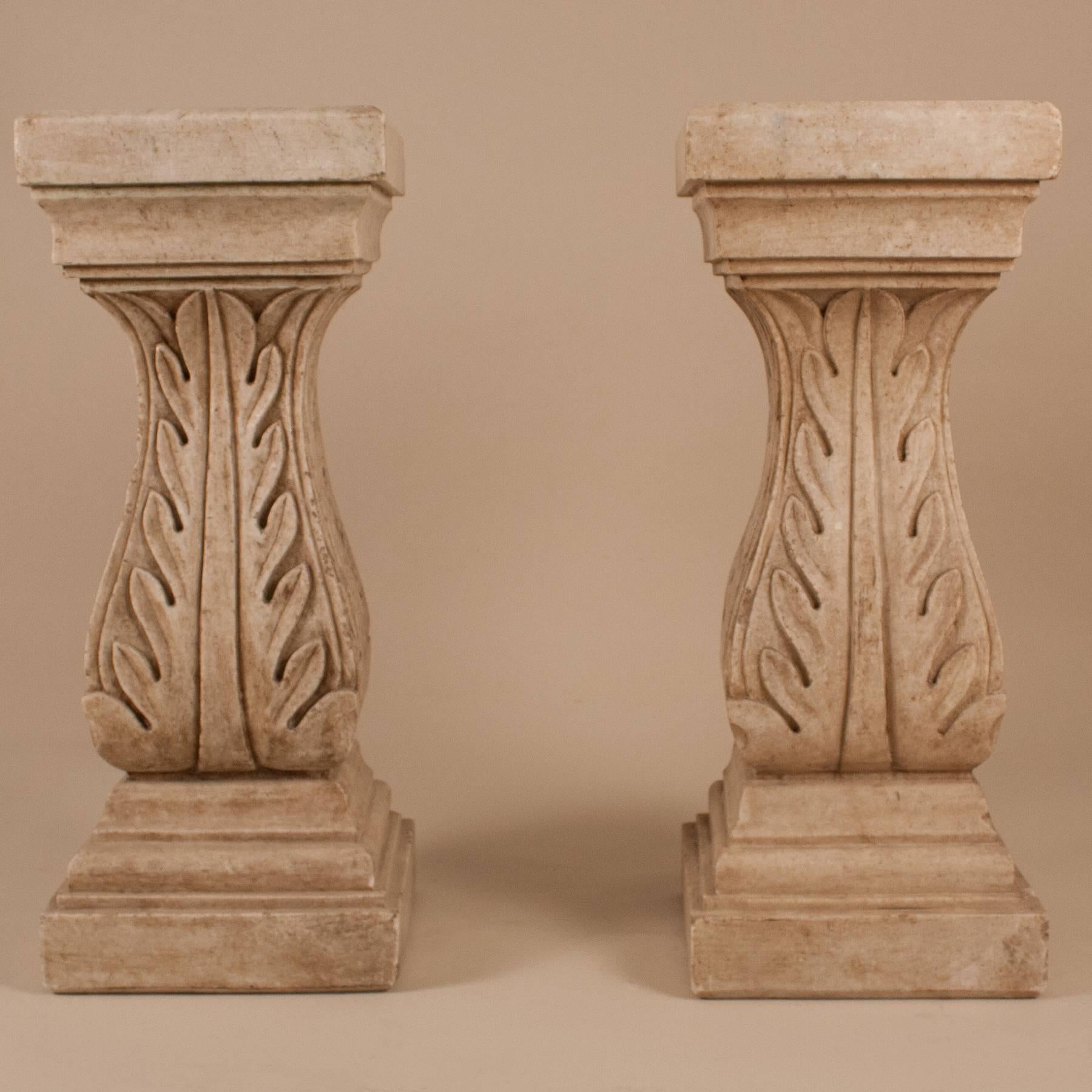 Pair of natural marble pedestals with carved acanthus leaves, circa 1950. Potential uses for these beautiful columns include as a console table base or as display stands for sculpture, etc.