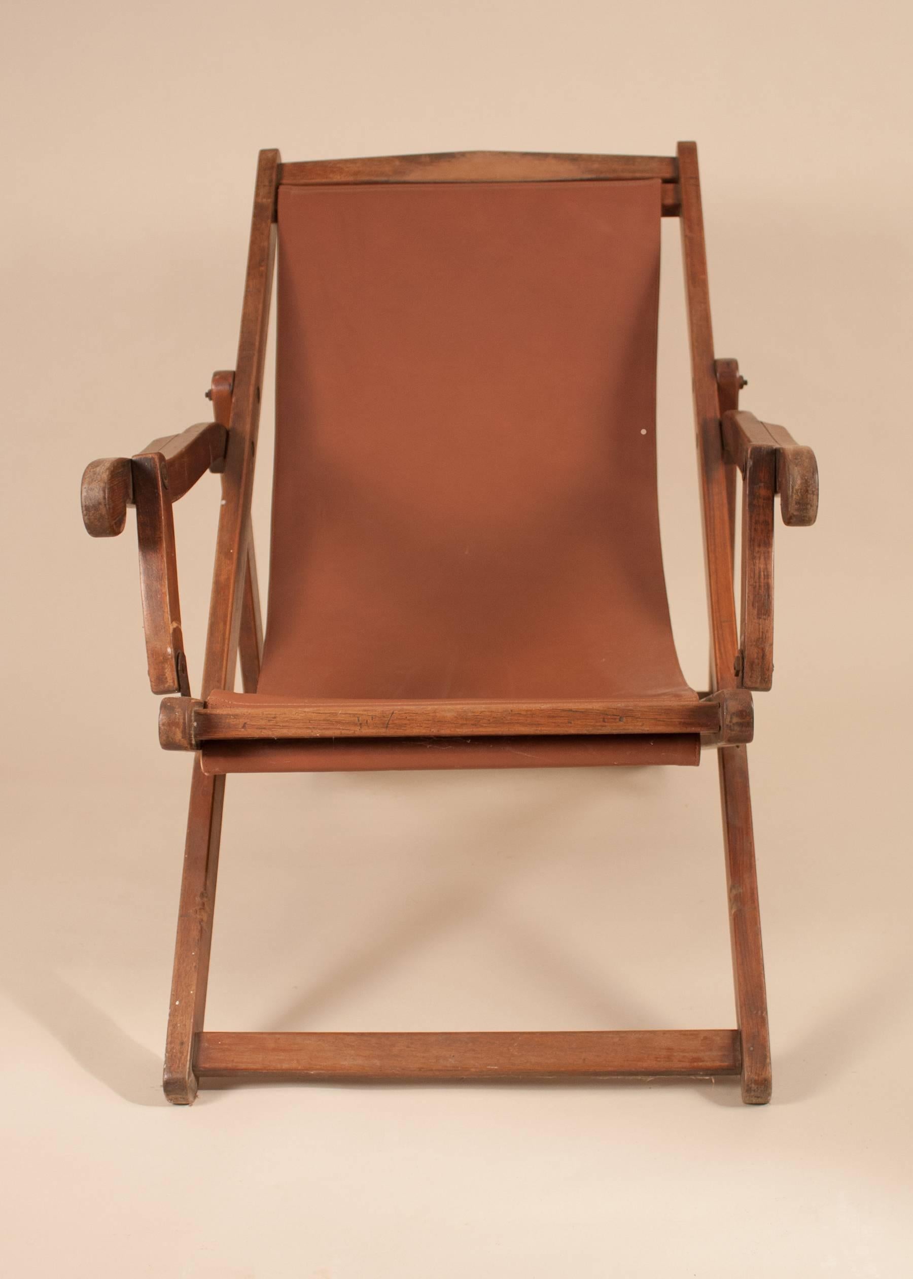 An authentic British Campaign folding, adjustable mahogany sling back chair, circa 1900, with its original wood finish. The plantation lounge chair's canvas sling was replaced some time ago with a chocolate-colored leather.