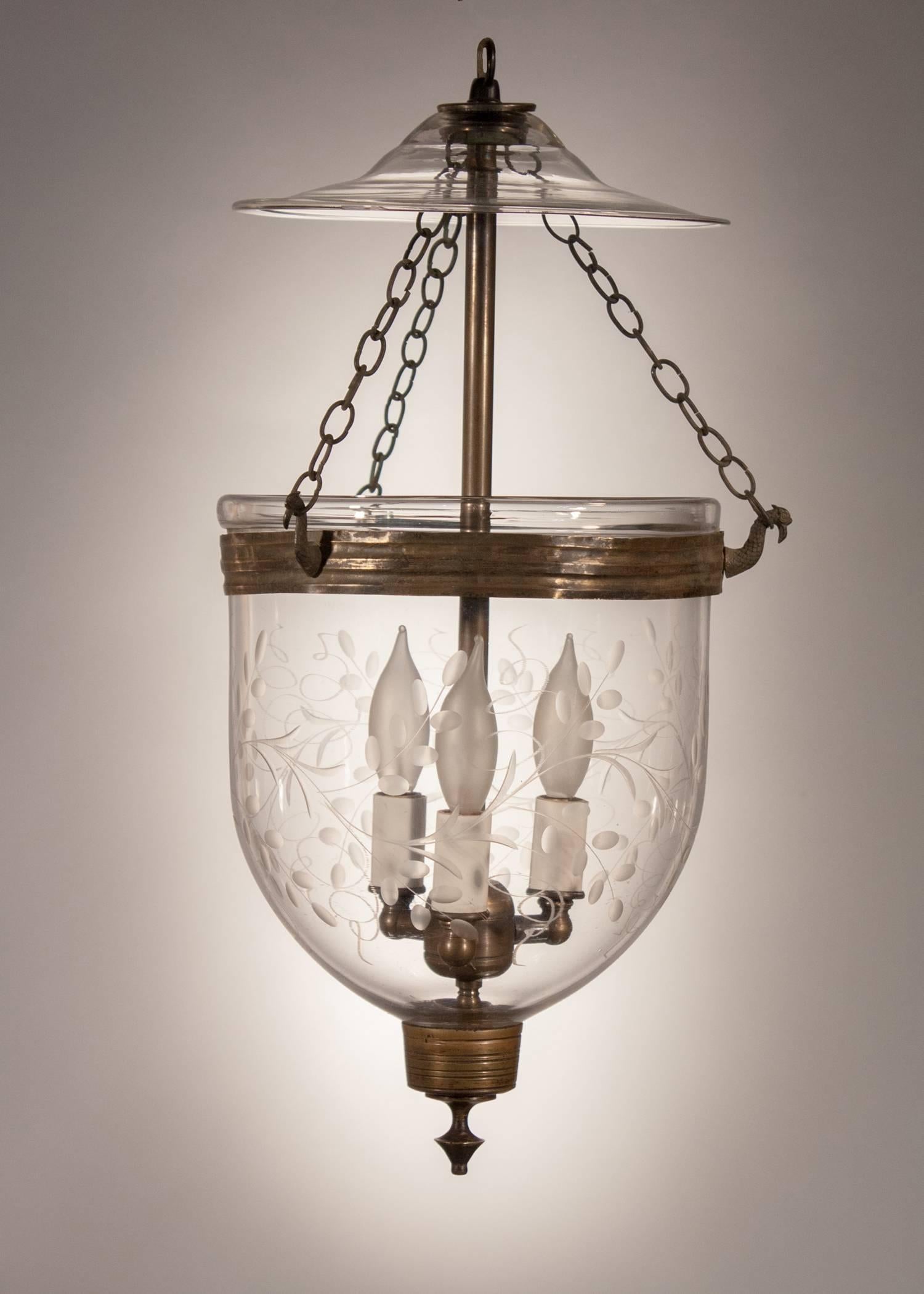 An English bell jar lantern, circa 1860, with a tasteful vine etching that complements this diminutive hall lantern beautifully. The quality of the hand blown glass is excellent and all of the pendant's brass details including its band, finial and