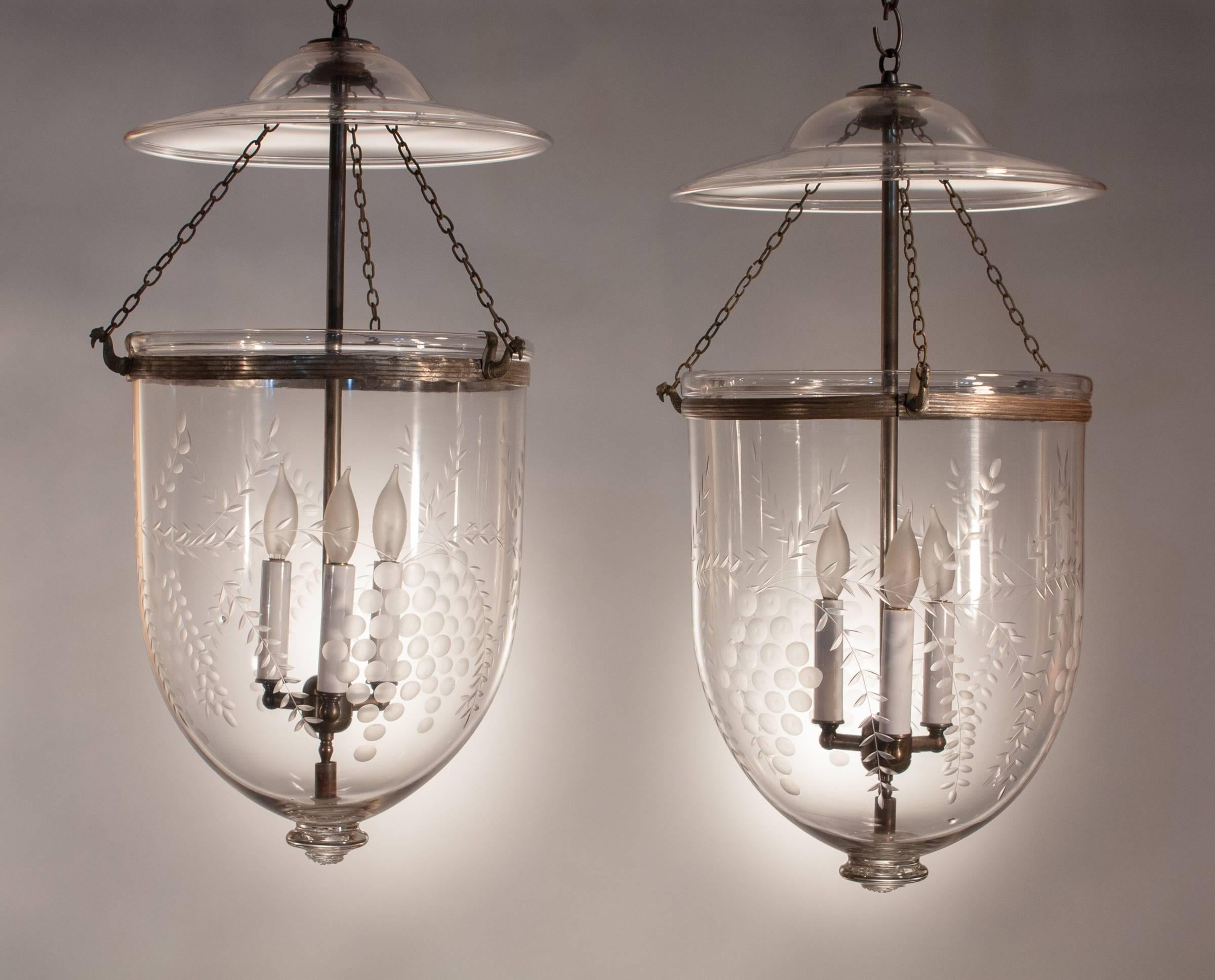 An outstanding and well-matched pair of 19th century, larger-sized English bell jar hall lanterns with an etched grape and vine pattern that complements the contours of these hand blown glass hall lanterns nicely. The pendants are in excellent