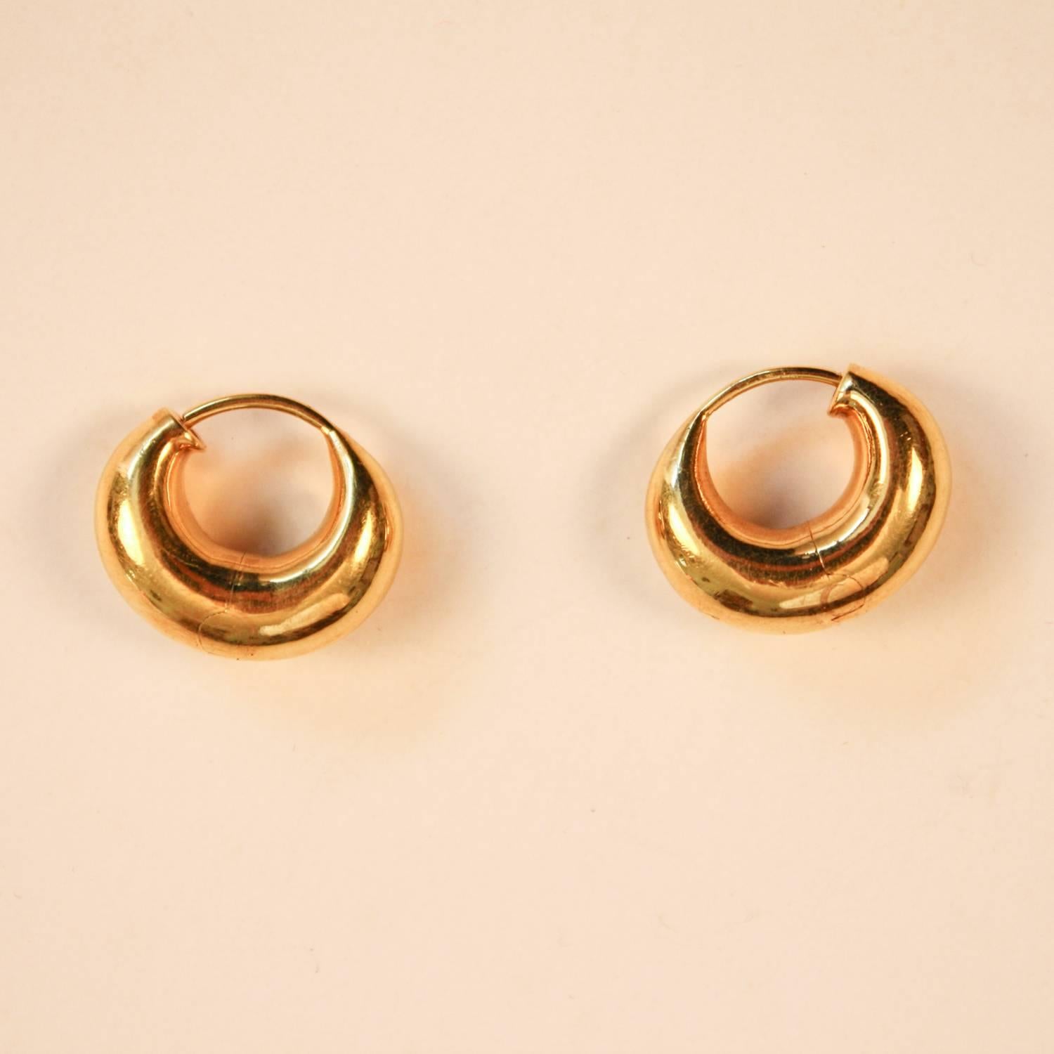 A beautifully designed pair of 18-karat yellow gold, hollow, hinged, hoop earrings. These cashew-shaped hoops are modestly sized and easy to wear. Each earring weighs 3g.
Diameter: .75