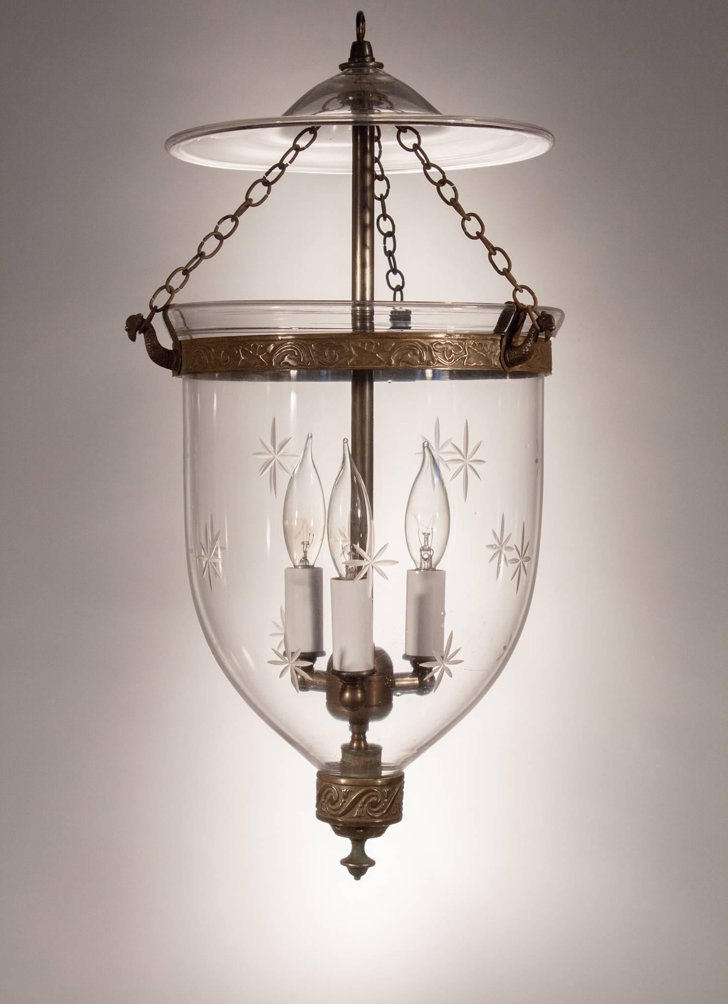 19th century handblown glass bell jar lantern from England with truly beautiful form and brass details. This smaller-sized hall lantern has its original smoke bell and candle holder finial with tassel motif in deep relief. The brass band, which has