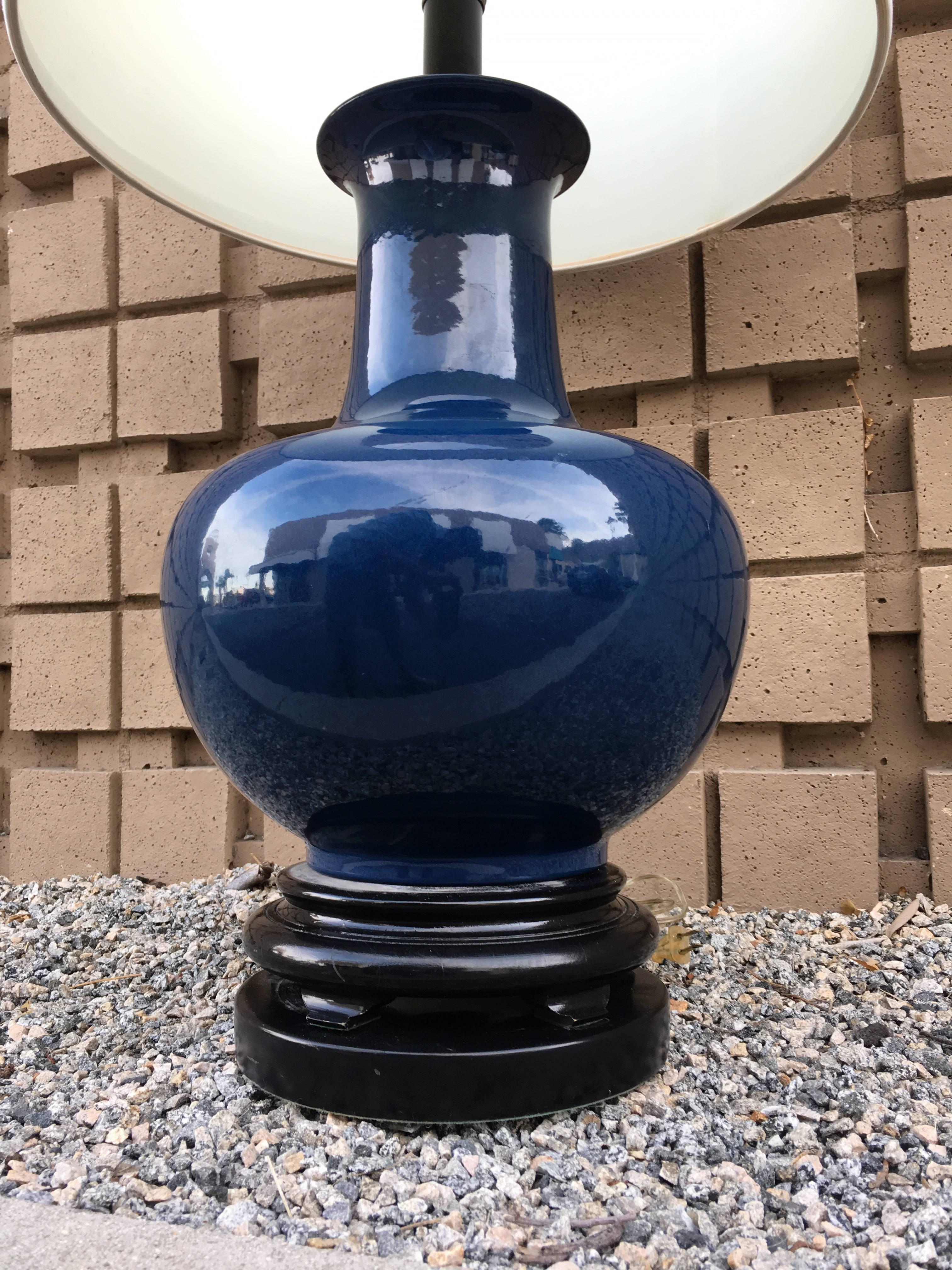 From a very upscale Palm Springs vintage estate, is a large, stylish indigo color ceramic table lamp. The impressive lamp has beautiful original barrel shade and thick black gloss wood base and matching finial. A very chic Mid-Century Modern lamp.