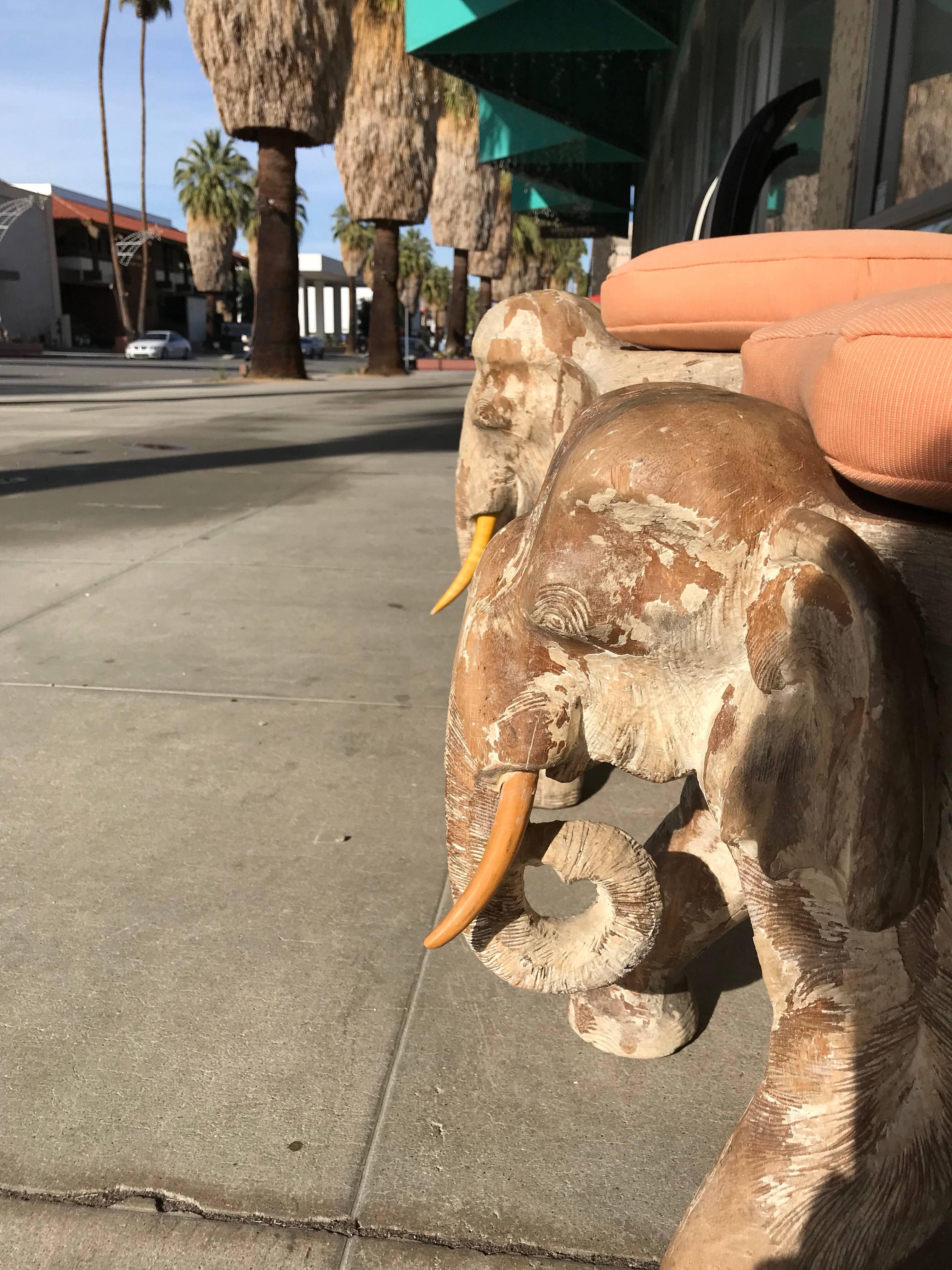 A very unusual and chic pair of Elephant Stools hand carved from solid wood that belonged to the rancho Mirage Estate of Ms Barbara Sinatra. They obtain their original custom seat cushions in citrus colored cotton. Believed to be custom made for her