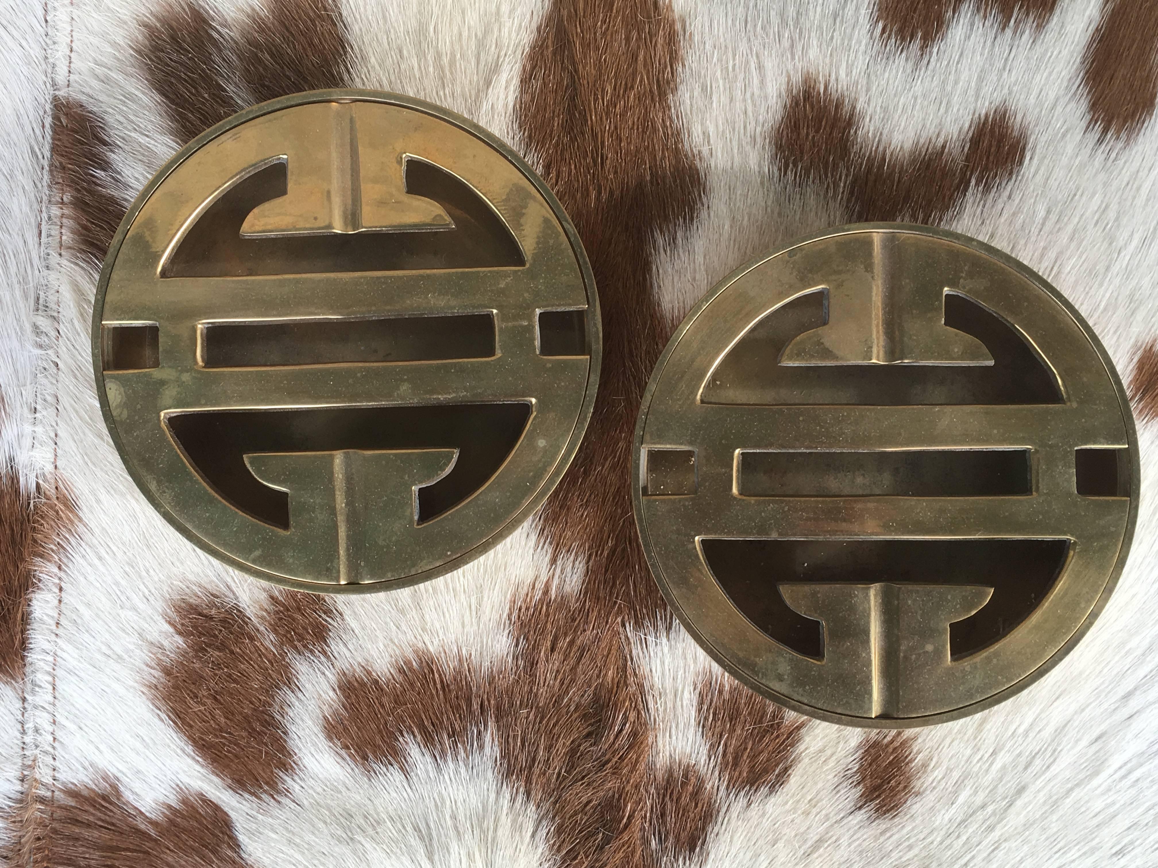 From a very chic Palm Springs estate, a pair of round chinoiserie ash receivers made in solid brass. All original patina and excellent condition. They were never used as ash receivers and were used for decorative purposes only. The perfect example