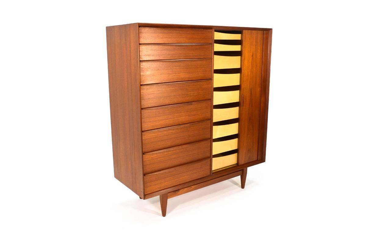 Fantastic large teak dresser designed by Arne Wahl Iversen for Falster. Featuring 17 drawers, eight on the left and nine on the right behind the tambour door, this piece provides ample storage in a small foot print. The tambour is microcut so that