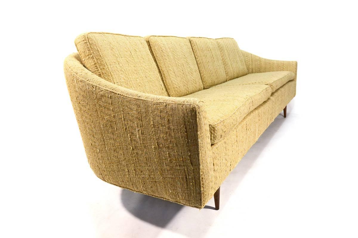 Absolutely beautiful sofa designed by Milo Baughman for Thayer Coggin. The original fabric is fantastic, with a lot of texture. It has a beautiful curve to the back on both ends and sits on turned walnut legs. This example is 100% original and looks