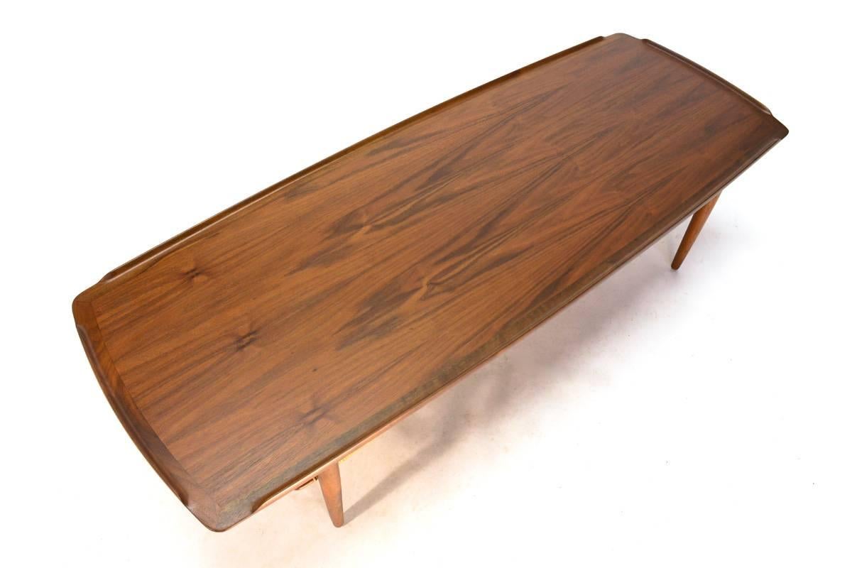 An exceptional example of this Classic Danish coffee table designed by Poul Jensen for Selig. The top features beautifully grained walnut, where normally these show very uniform and non-interesting wood. The lower shelf with its original cane is in