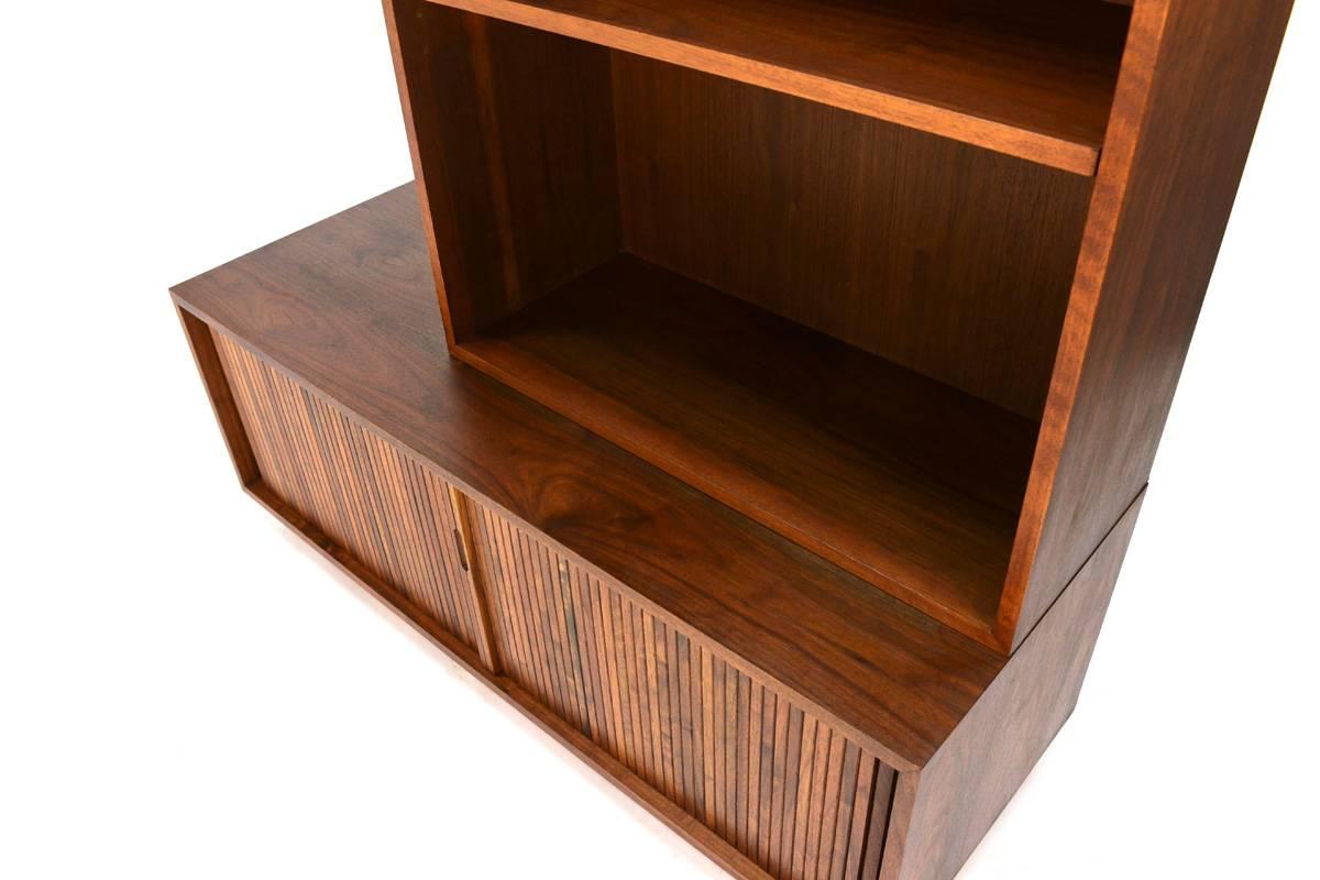 A low walnut record storage cabinet with tambour doors and bookshelf top produced by Glenn of California and designed by Milo Baughman. These pieces feature beautiful walnut throughout. There are in extremely nice original condition, with only very