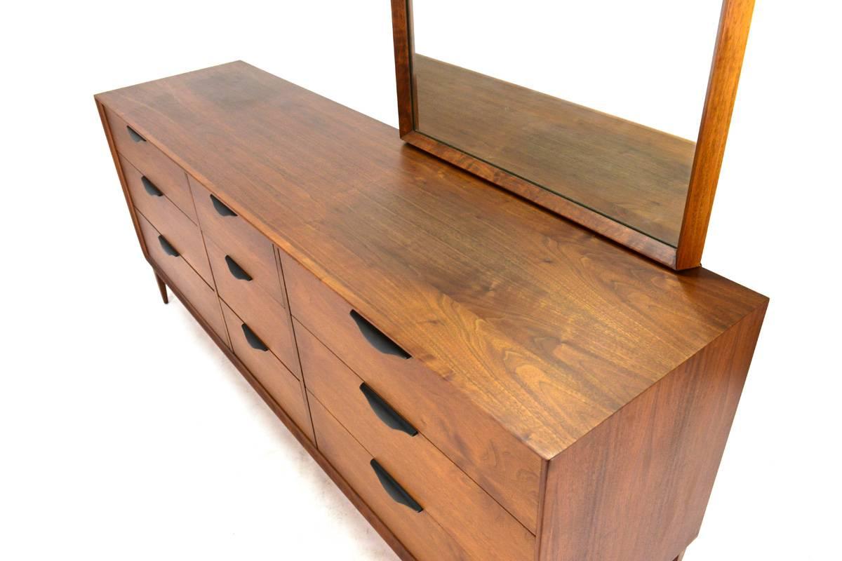 Very nice nine-drawer dresser in American walnut by Dillingham. A very high quality piece in very good original condition. The ebonized sculpted wood pulls offer a nice contrast to the rich tone of the walnut. The top shows some very slight