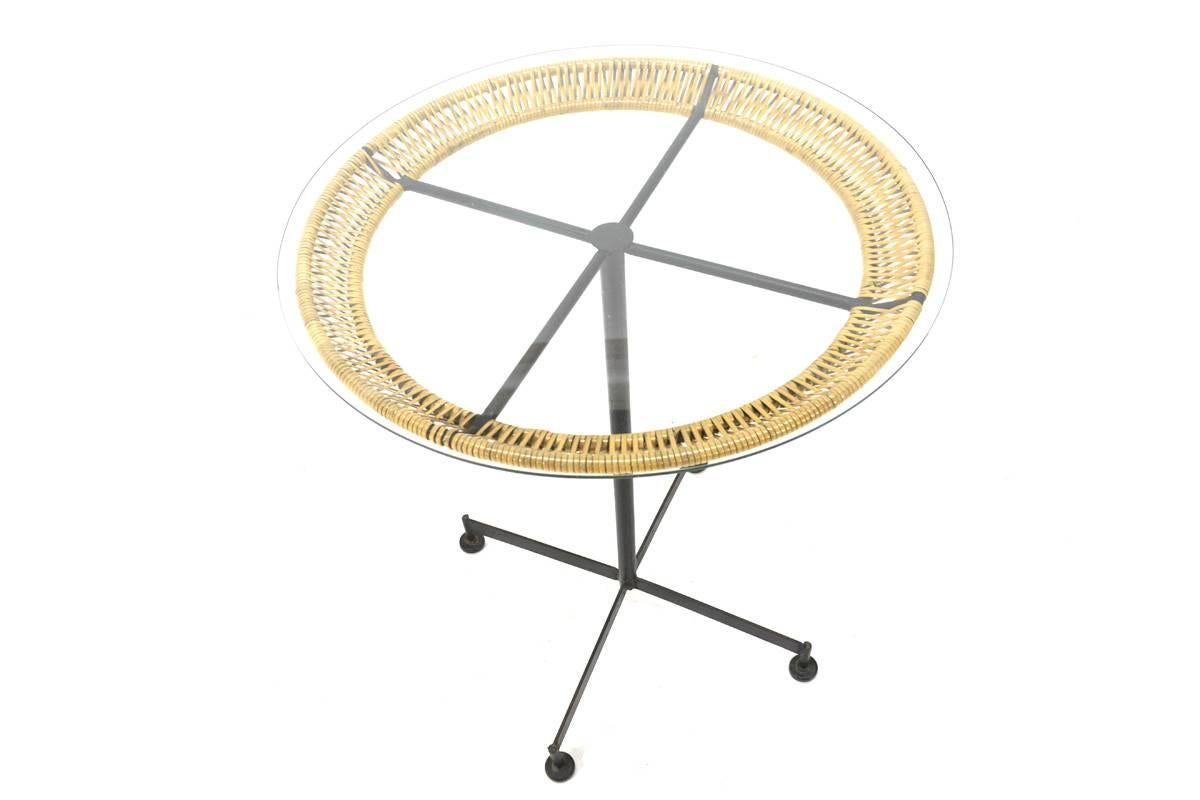 Very nice small dinette or occasional table by Arthur Umanoff. Simple iron frame with the woven rattan detail around the edge that you see in many Umanoff pieces. The frame shows some very light oxidation, the rattan wrap is in excellent condition.