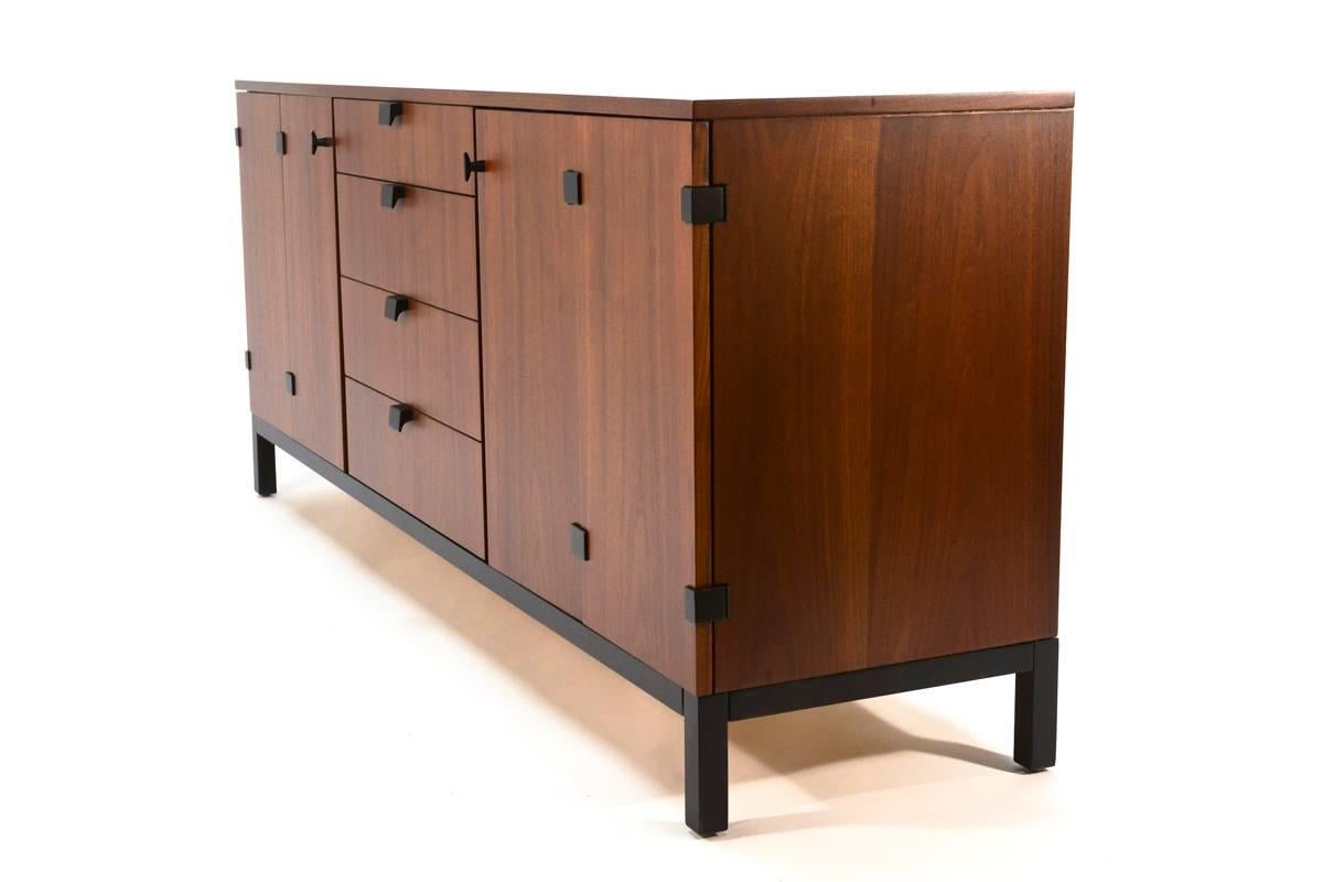 Gorgeous walnut credenza designed by Kipp Stewart for Directional. Beautiful walnut with black accents in the hinges, handles and base. Ample storage with the four central drawers and large cabinets behind the bi-fold doors. This piece has been