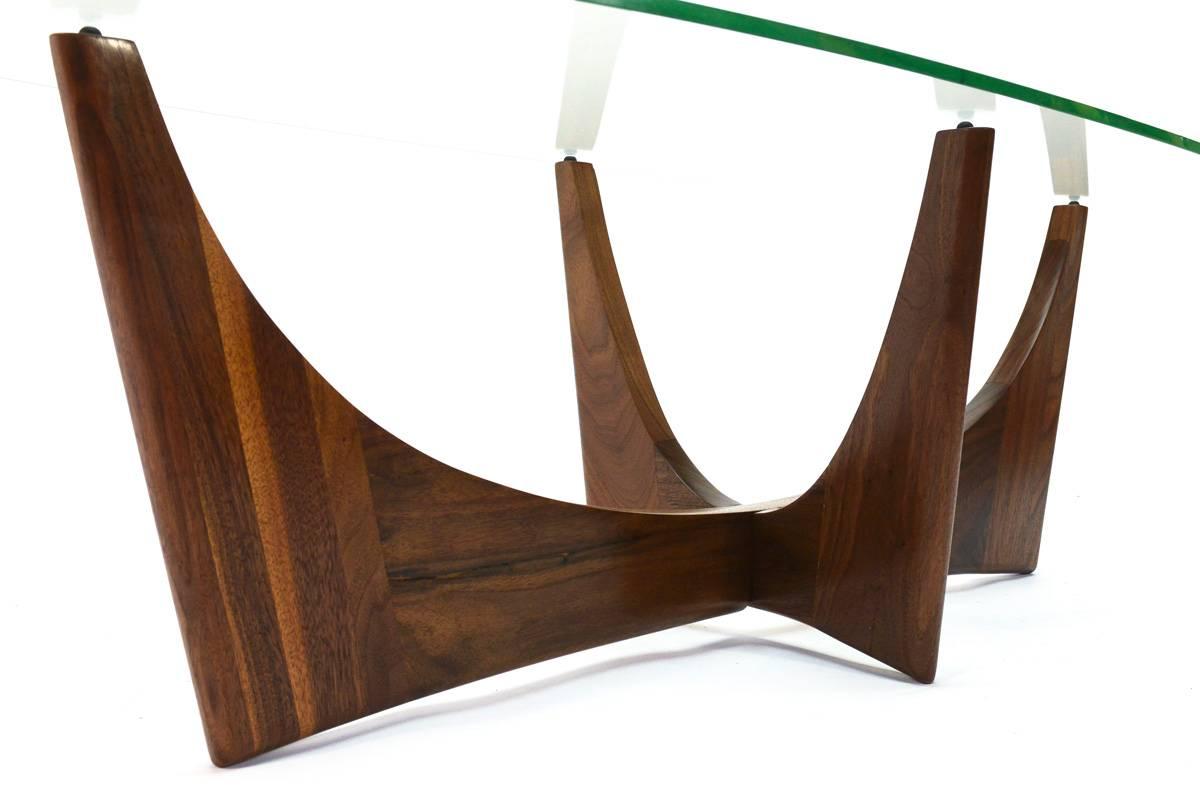 Beautiful sculptural walnut coffee table by Adrian Pearsall for Craft Associates. The color and grain of the walnut on this piece is truly fantastic. The elliptical glass top is original, it does scratching across the surface, and two small chips