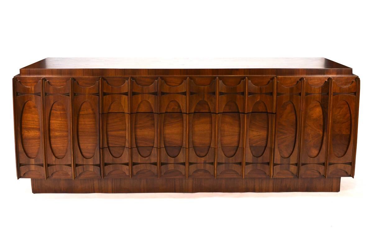An absolutely beautiful piece. The drawer and door fronts feature three dimensional sculpted walnut panels. The entire piece utilizes walnut with beautiful grain and color throughout. Dates to the 1970s, unfortunately the designer and manufacture