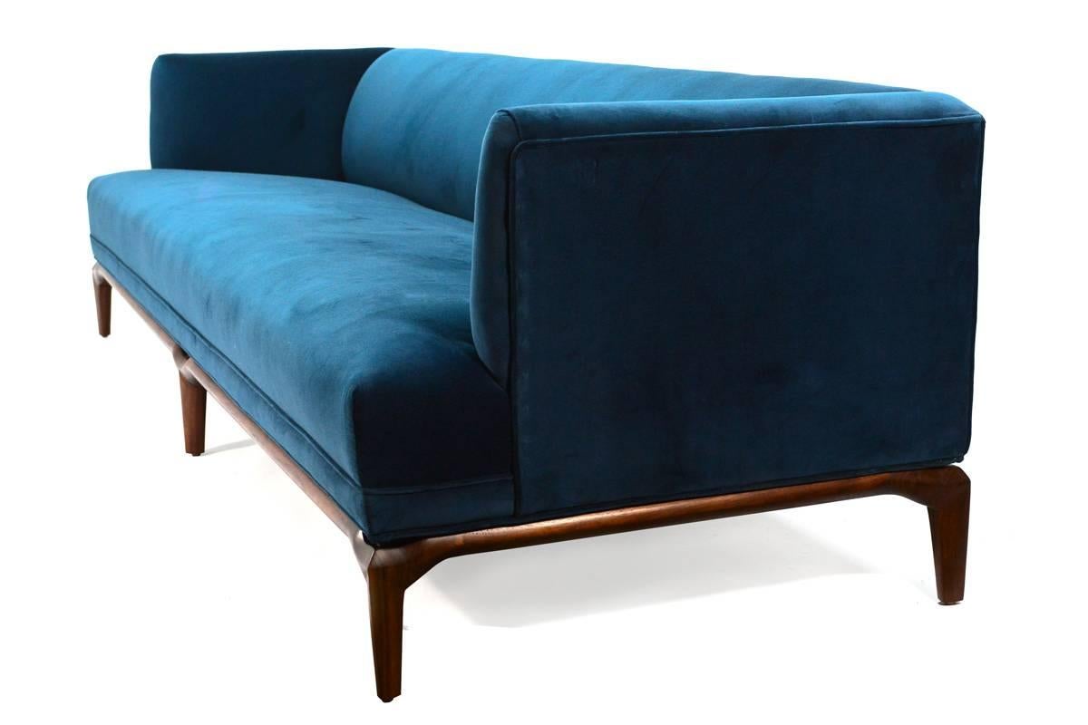 Beautiful sofa designed by Maurice Bailey for Monteverdi-Young in the early 1960s. This piece was reupholstered by the previous owner in a deep blue velvet, which sets off beautifully against the sculptural walnut base. Shows light normal wear from