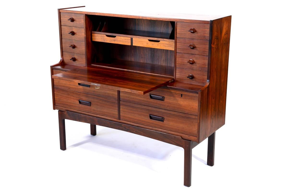 A fantastic large-scale secretary desk designed by Arne Wahl Iversen for Vinde Mobelfabrik of Denmark. Produced in beautiful rich rosewood. This piece offers a huge amount of storage with four large drawers in the base and four small drawers on each