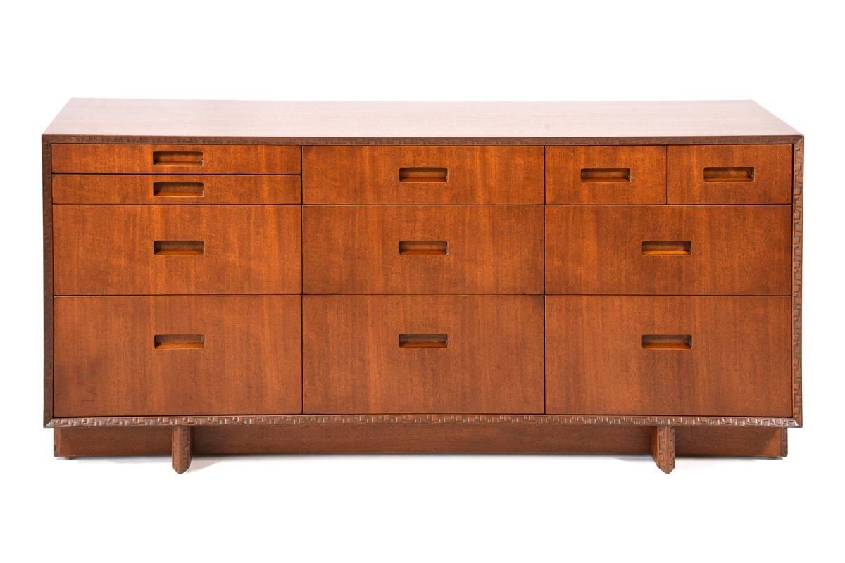 Beautiful dresser designed by Frank Lloyd Wright for Henredon as part of the Taliesin collection in 1955. Features distinctive carving around the face and on the legs. This piece has been restored and is in excellent condition. Retains both the