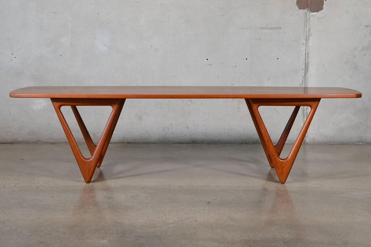 A large Danish teak coffee table designed by Kurt Ostervig for Jason Mobler. This table is all about those large sculpted teak 'V' shaped legs. The top has a slight taper giving it a surfboard or boat shape. This piece is in original condition,