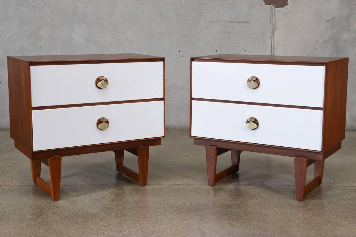 Arguably one of Stanley Furniture's most icon lines produced in the Mid-Century era was this line of case pieces with walnut bodies, white lacquered faces and large brass spade shaped handles. These nightstands are no exception. These pieces feature