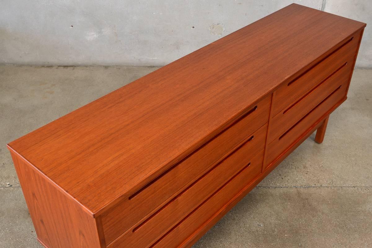 A low six-drawer teak dresser designed by Nils Jonsson for HJN Mobler of Denmark in the 1960s. A great simple design in richly toned teak. This piece is in very good original condition with very light normal wear from use.

Measures: 71