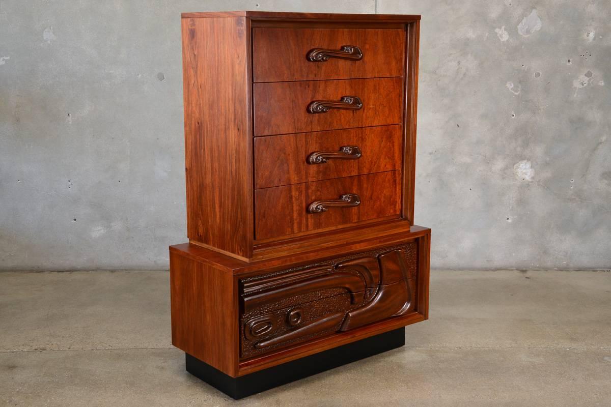 Beautiful sculptural highboy six-drawer dresser. Very richly toned tropical mahogany with molded handles and panels that mimic carving on the lower drawers. This piece has been fully restored and is in excellent condition. By Pulaski Furniture
