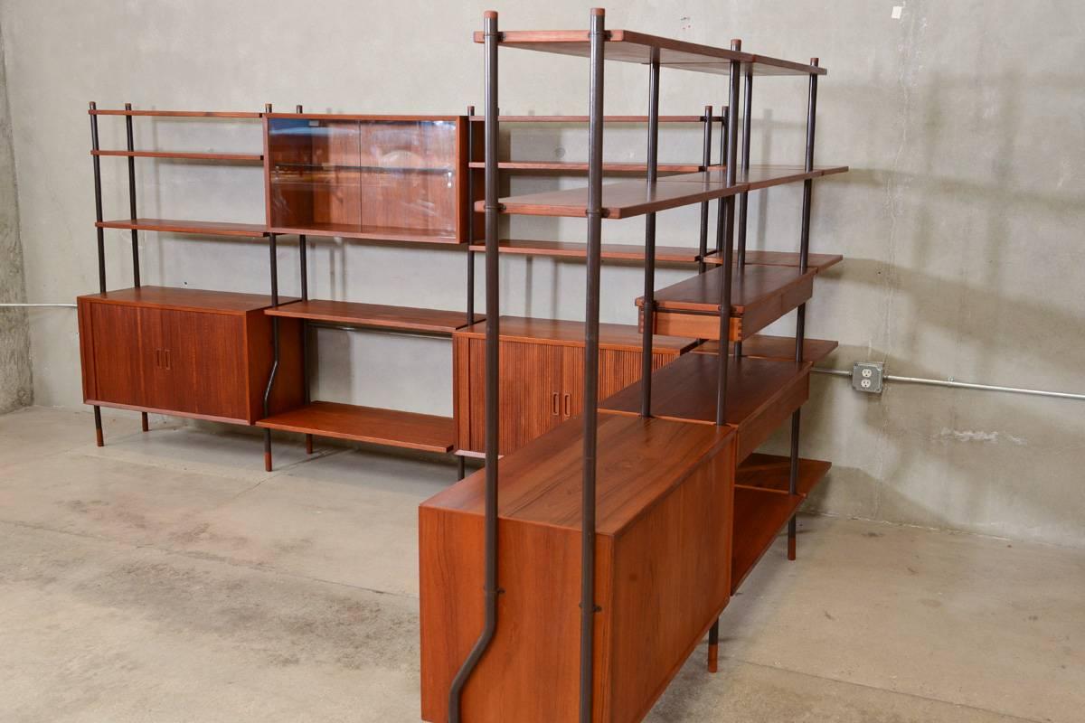 An enormous six section freestanding Danish teak wall unit or room divider by Lyby Mobler. This piece is entirely modular and can expand and contract to suit your needs. It is finished on all sides so it would make an excellent room divider. The