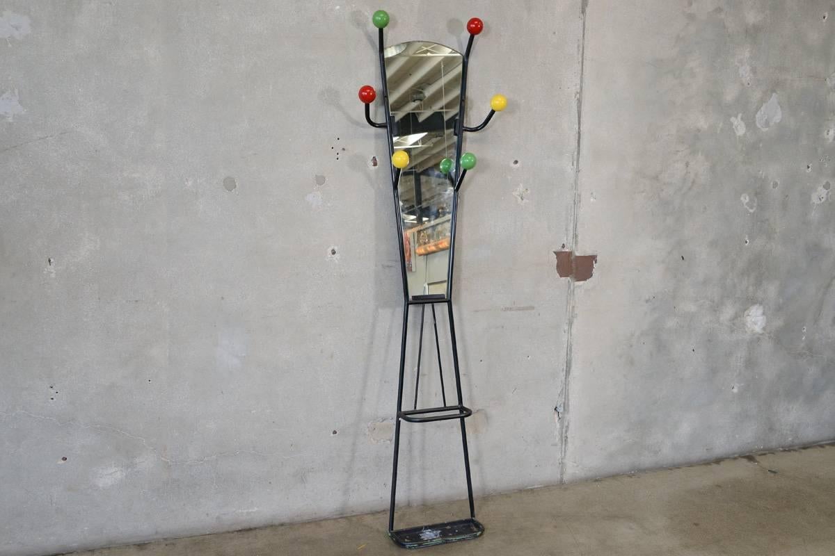 A very fun French coat or hat rack from the 1950s with an integrated mirror and umbrella stand. Brightly colored balls sit at the end of the tubular metal arms to hold hats, coats, or whatever else you need them to hold. The lower portion has a drip