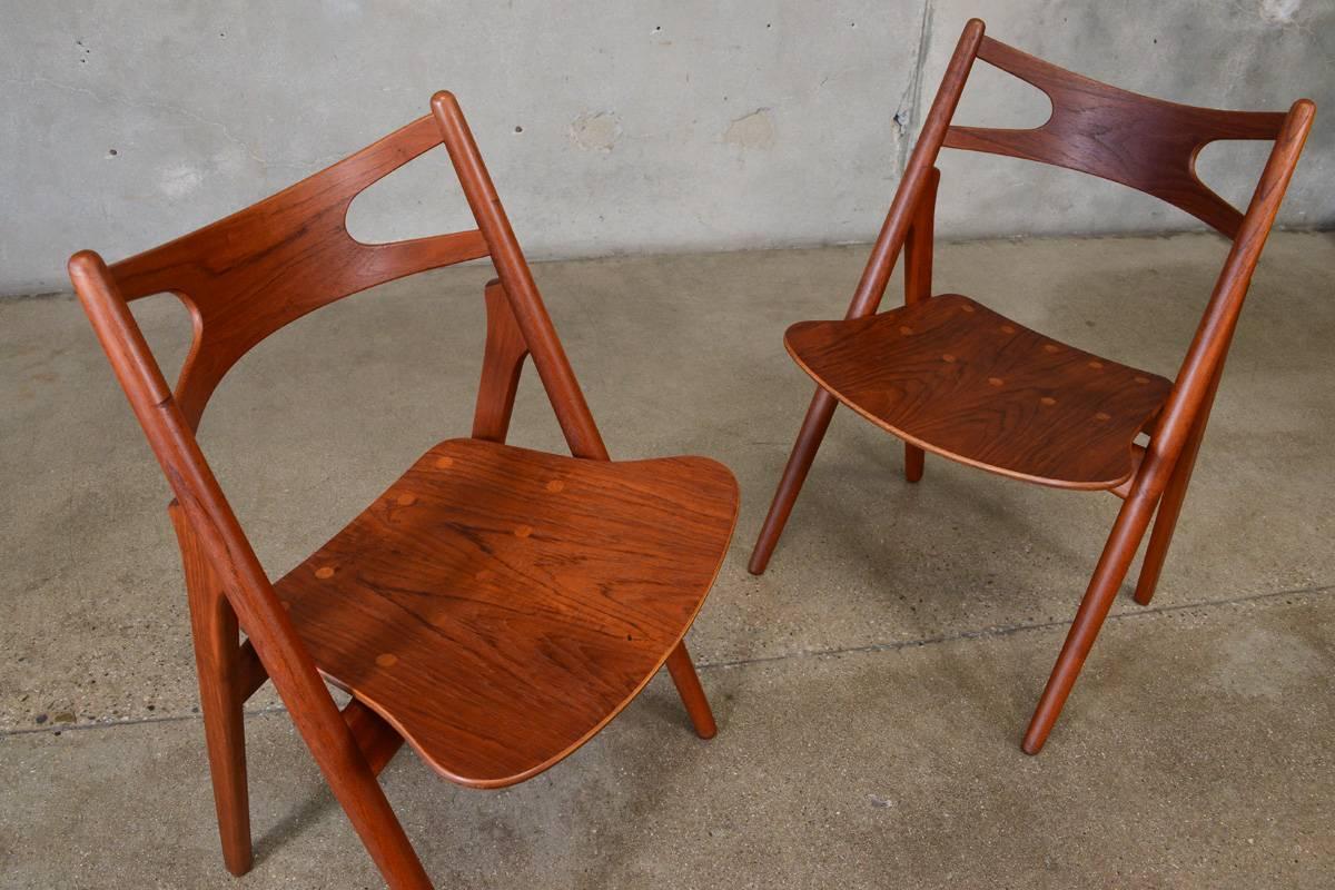 Gorgeous pair of CH29 chairs in teak designed by Hans Wegner for Car Hansen & Son in 1952. This early pair feature all teak construction including the beautifully grained seats with their contrasting joinery details. These are in very nice original