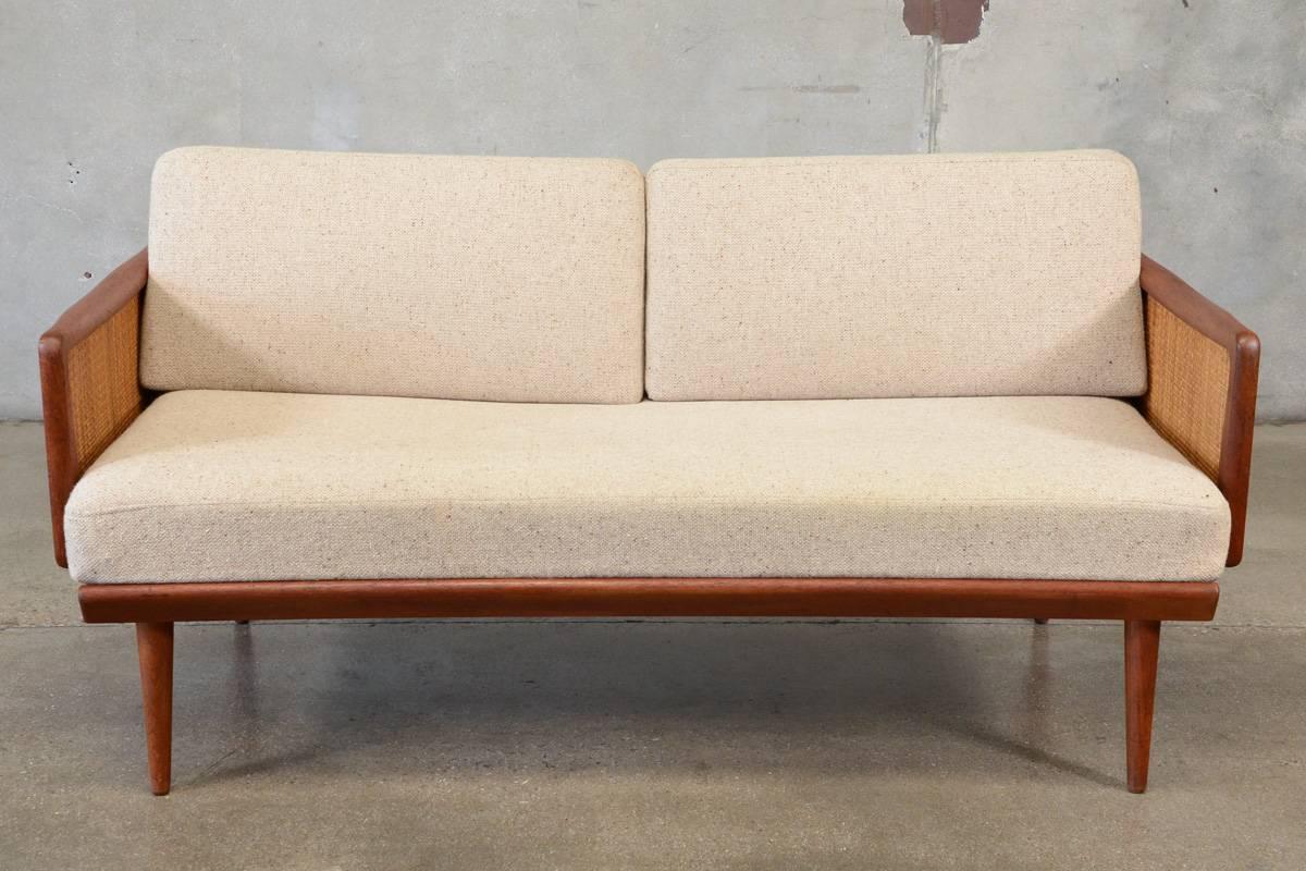 A rare sofa/daybed designed by Peter Hvidt & Orla Mølgaard-Nielsen for France & Daverkosen. The FD451 sofa/daybed has unique fold down arms that allow this piece to easily and quickly go from a compact sofa to a daybed. Features a solid teak frame