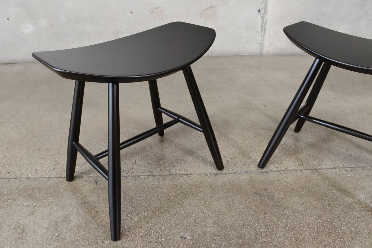 A pair of J63 Stools designed by Ejvind Johansson for FDB Mobler. These offer a simple design of steam bent ply over dowel legs. These have been restored with a black finish as they originally had.

Measures: 19