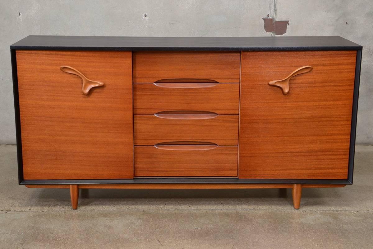 A very fun 'treasure chest' dresser designed by Paul Laszlo for Brown and Saltman. This piece offers a ton of storage with 12 plastic drawers behind the left door and four adjustable drawers behind the right door. Built with beautiful mahogany, the