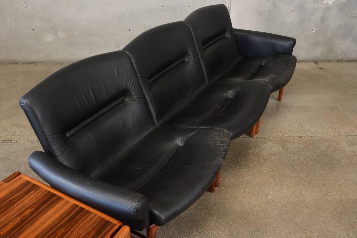 Fantastic modular set in rosewood and black leather. Includes three seats and one table that can be arranged in a number of ways. The original leather shows a nice patina without significant wear. The solid rosewood frames of the two seats with arms