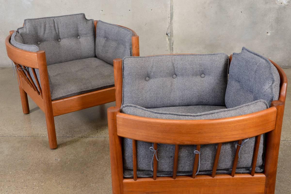 Very nice pair of spindle lounge chairs. The construction of the solid teak frames is reminiscent of designs by Borge Mogensen. The cushions are newly upholstered in a warm gray and have been shaped to match the profile of the chair frames. The