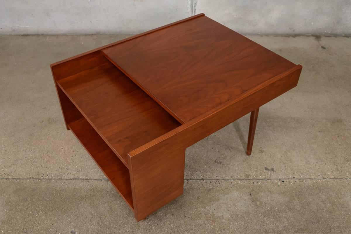 Beautiful walnut side table designed by Milo Baughman for Glenn of California, 1950s. This piece has been totally restored, and it shows off the color and grain of the walnut very nicely. The upper shelf is intended to hold magazines and the lower