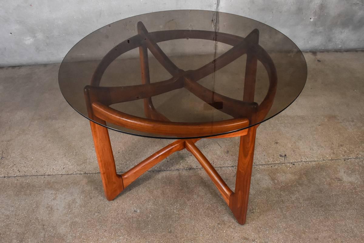 Beautiful sculptural walnut dining table designed by Adrian Pearsall for Craft Associates. This is the model 2458-T. This piece is in lightly restored original condition. There is some light wear as you would expect with age. The smoked glass is