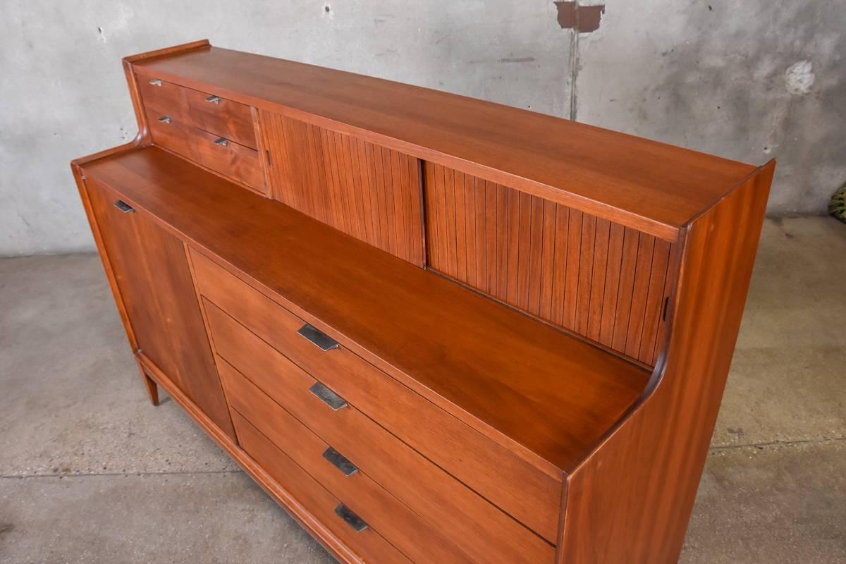 A walnut 'Dimension' credenza produced by Cavalier and designed by Arthur Umanoff in 1957. This piece has a lot of really nice design details, like the beveled edges that wrap the whole piece and the vertical groves on the upper and lower doors. The