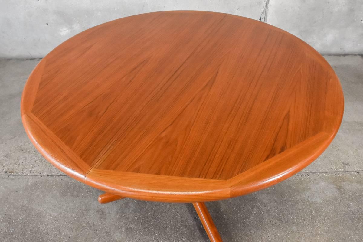 A Classic round Danish teak dining table that extends from 49
