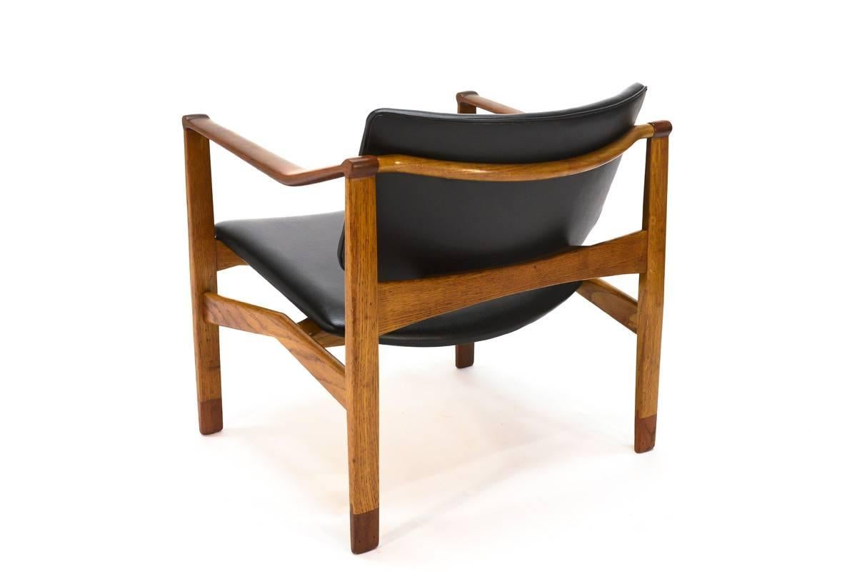 Beautiful chair designed by architect William Watting and produced in Denmark. The uniquely designed architectural frame is mixture of teak and oak, with the bulk of the frame being oak and the arms and ends of the legs being teak. This creates a