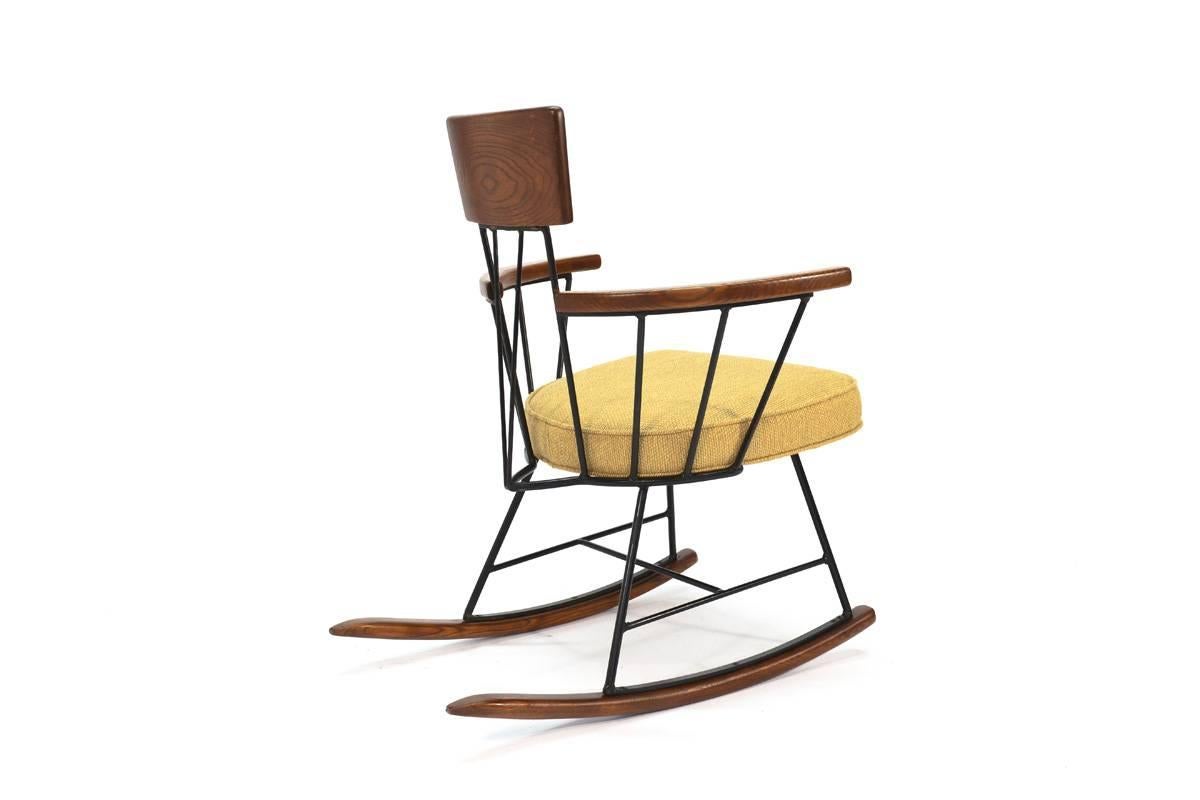 Great modernist rocking chair designed by Richard McCarthy for Selrite. Featuring an iron frame with oak arms, backrest, and rocking rails. The wood has all been refinished and the seat has been reupholstered in a nice warm mellow yellow