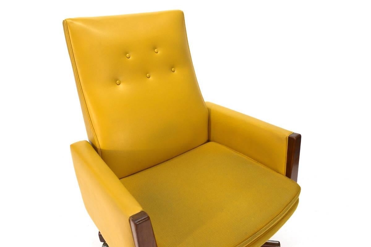 All original executive office chair by Jens Risom. Fantastic canary yellow vinyl and fabric seat are accented with walnut trim on the front of the arms and the base. Retains both original labels under the seat. The swivel, tilt and height adjustment