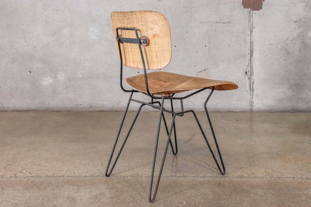 An iron and fiberglass chair designed by Hobart Wells for Lensol-Wells in early 1950s. This is the dining/desk chair height. This example is in 100% original condition. The grass cloth textured seat and back show fading and discoloration as