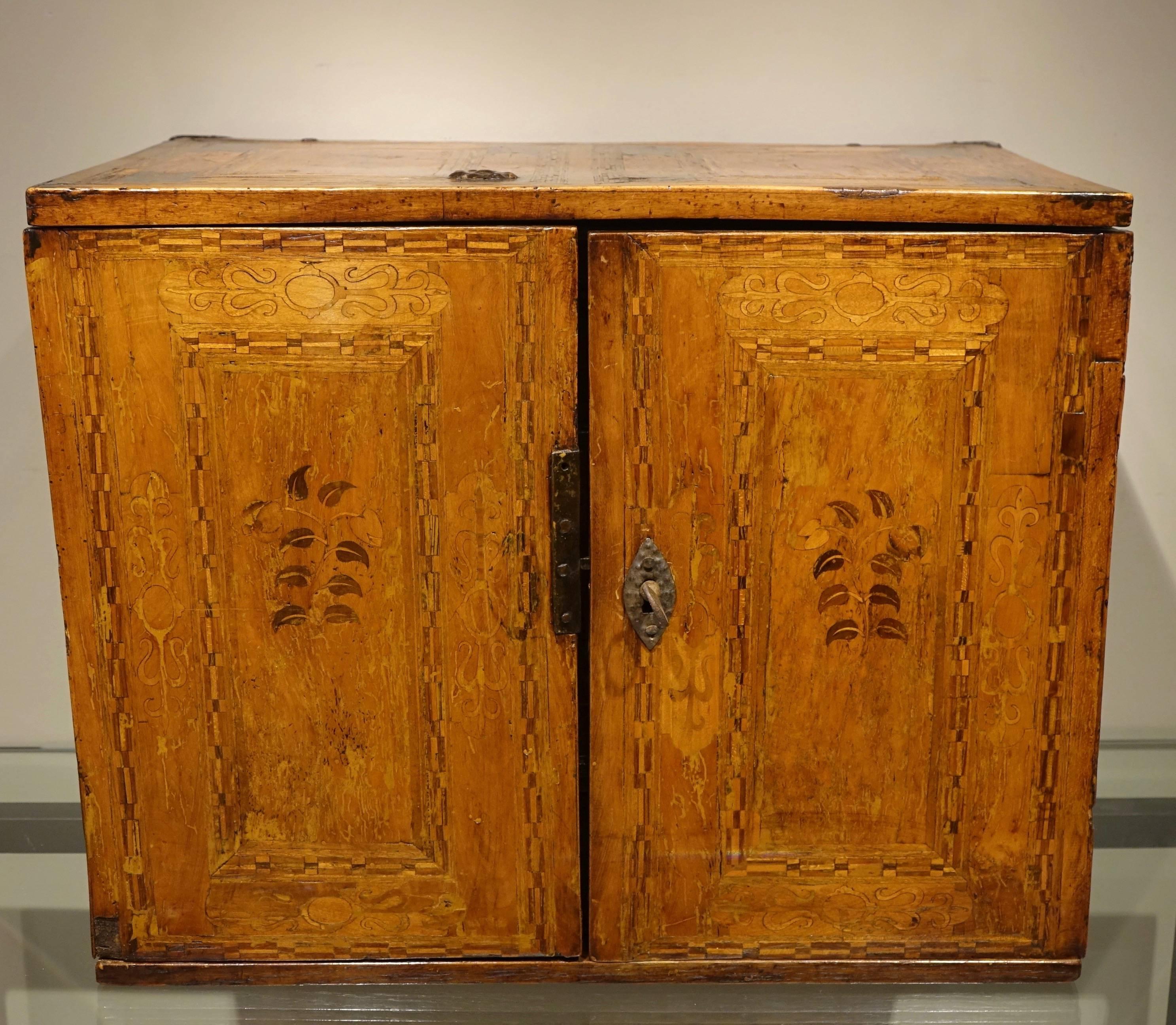 Kabinettschrank decorated with floral and architectural motifs, inlaid in intarsia.
Two doors open on a series of seven drawers, two of which are fake and are part of the top belt concealing the top of the cabinet.
Beautiful locks with clapper,
