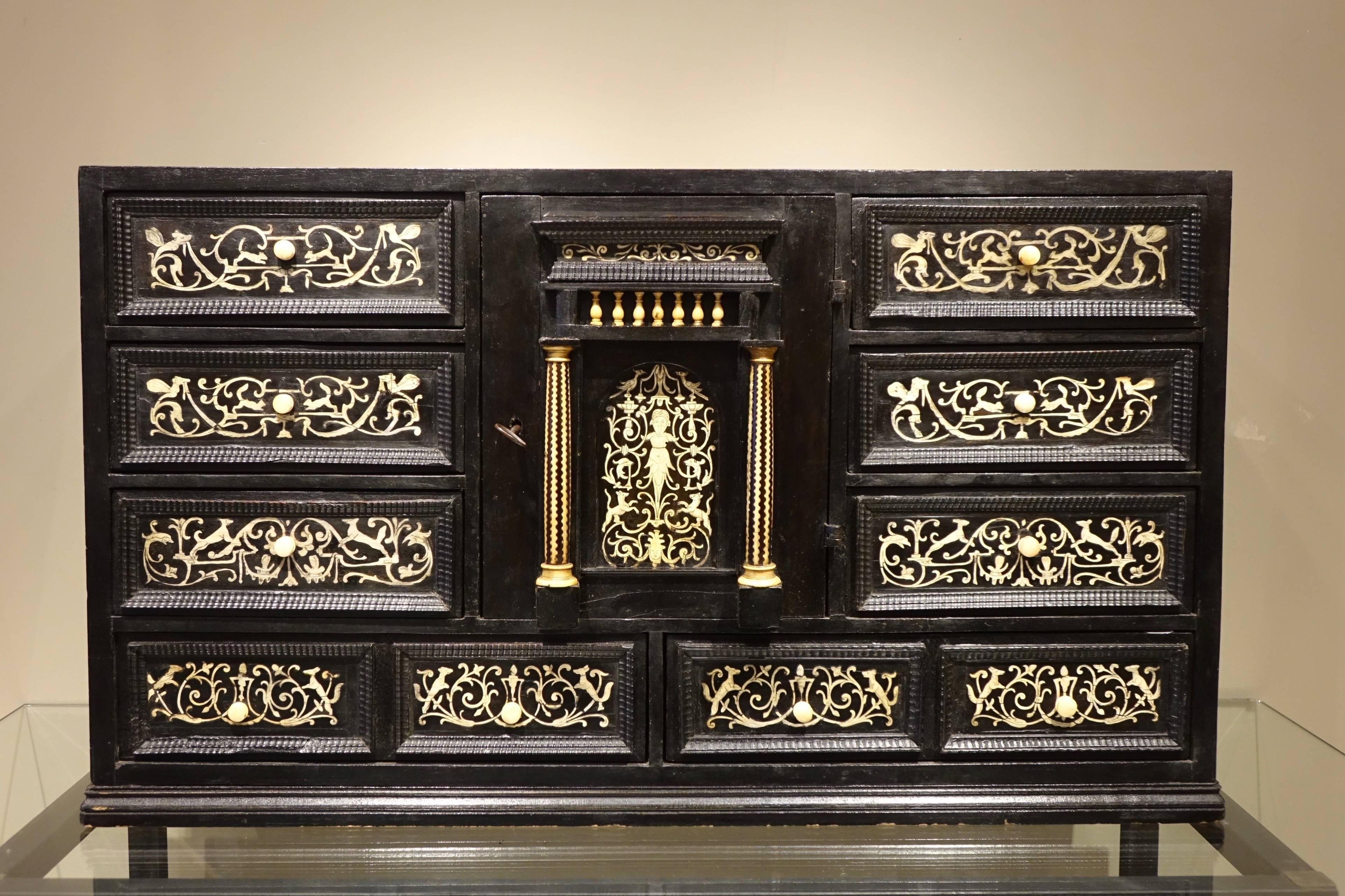 A 17th century ebonized wooden cabinet with inlay, decorated with scrolls, grotesques and fantastic animals.
Northern Italy
Wooden core of coniferous, inside drawers and slides in oak, molding of drawers in ebony.
Eight drawers in the front.
A